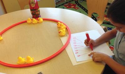 A child writing down numbers on paper.