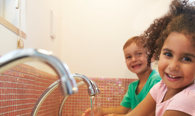 two children happily washing their hands