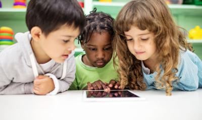 children gathered around an ipad