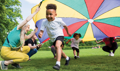 Children playing under a colorful parachute.