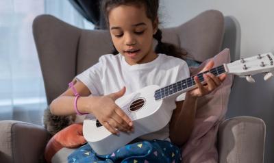 child laying ukulele
