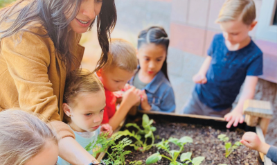 a teacher showing students a garden