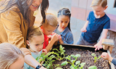 a teacher showing students a garden