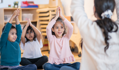 children and a teacher doing yoga poses