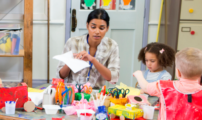 a teacher overseeing arts and crafts in a classroom