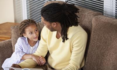 a parent talking to a child on the sofa