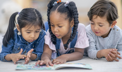 three children reading together