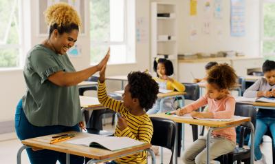 Teacher high fiving student in a classroom