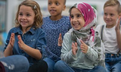 Students in a classroom smiling and clapping