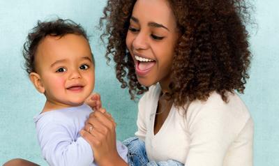 Mother laughing and holding son.