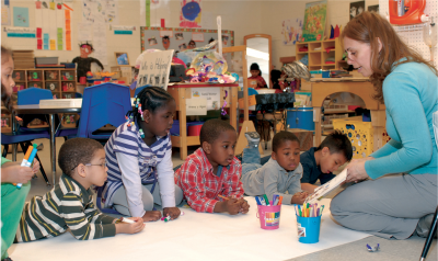 Teacher helping preschool class