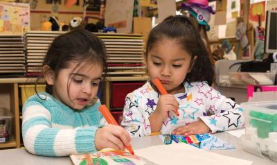 Two students drawing in a classroom