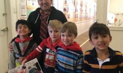 Teacher and students smiling with artwork