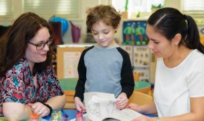 Teacher meets with parent and child at a conference