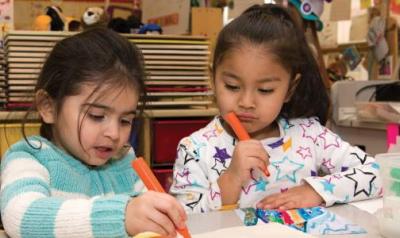 Two young children draw with markers