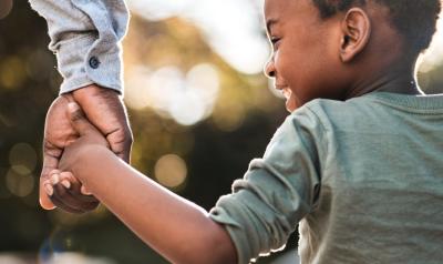 a child holding hands with an adult