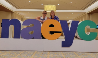 NAEYC members standing behind the NAEYC letters at Annual Conference