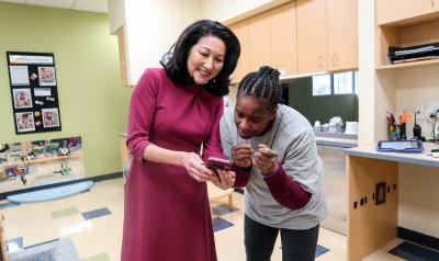 NAEYC CEO Michelle Kang showing an educator something on her phone
