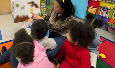 An educator reading to children in her classroom