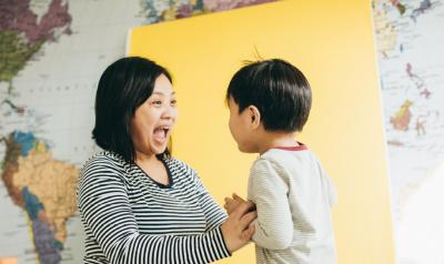 Mom and son smiling at each other with map in background