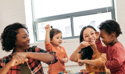 two teachers dancing with children