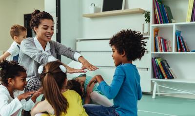 A teacher talking and engaging with a group of kids