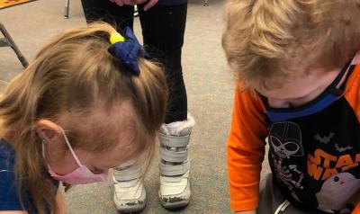 two children looking at a project in a classroom