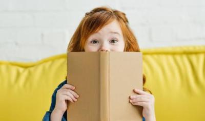 a young girl holding a book