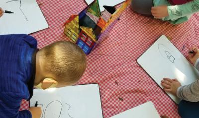 children drawing on a picnic blanket