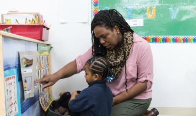 a teacher showing a child a picture