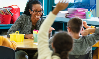 a teacher responding to children raising their hands