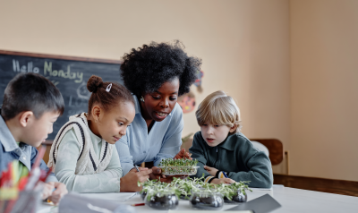 A teacher teaching students about plants in a classroom