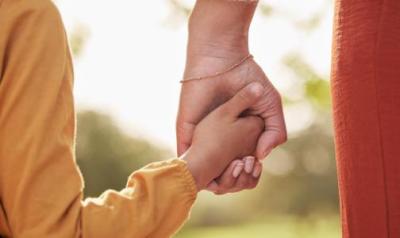 child and adult holding hands