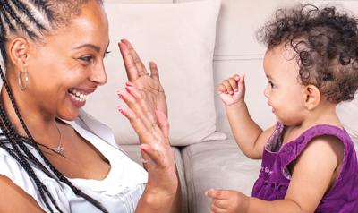 Toddler playing hand game with mother