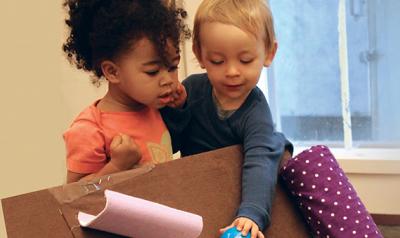 Two toddlers playing with materials
