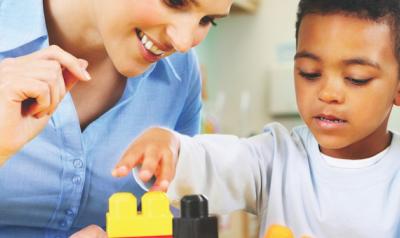 Teacher observing student build blocks