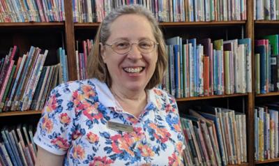 Betsy Cohen in front of a full bookcase