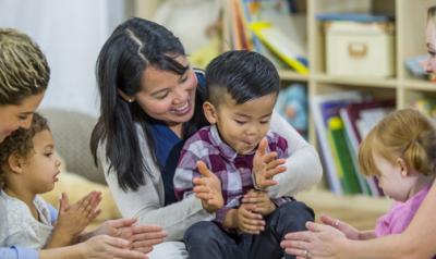 a group of toddlers and parents clapping together