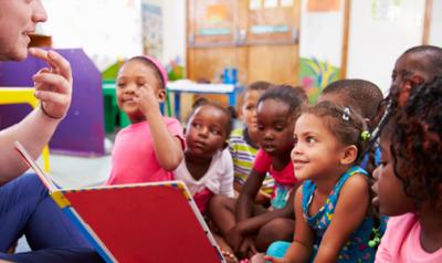 children listen attentively to teacher in class