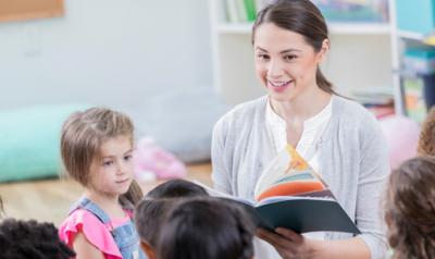 Students listen while the teacher reads a book out loud