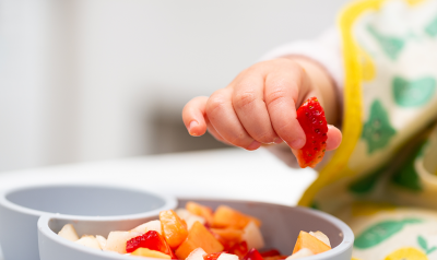 a child picking up some fruit