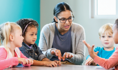 a teacher talking to a group of children