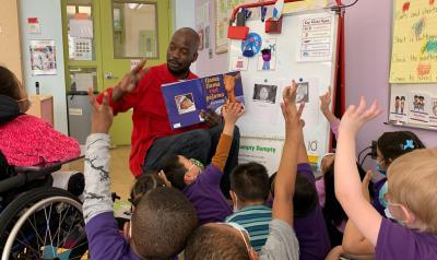 a teacher instructing his young students with a book