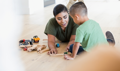 an adult playing with a child on the floor