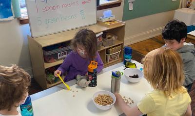 children using food to learn math on a table