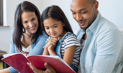 parents reading a book with a child