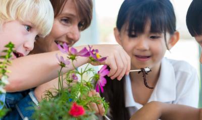 children observing a worm in a garden