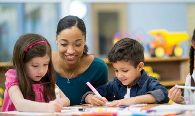 A teacher observing students drawing.