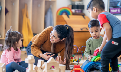 a teacher observing children playing with blocks