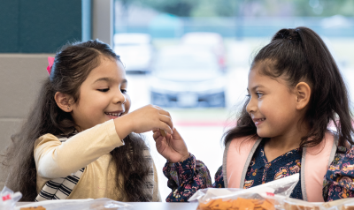 Two children talking about their lunch 